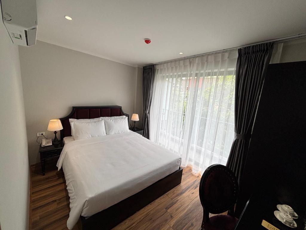 a bedroom with a bed and a large window at Classy Central Hotel in Hanoi