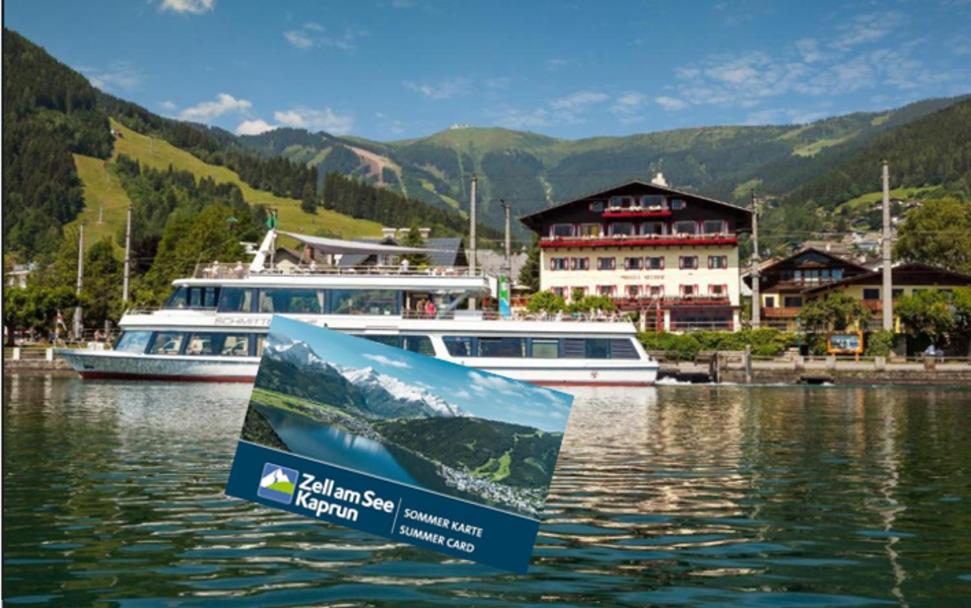 a sign in the water with two boats in the water at Hotel Seehof in Zell am See
