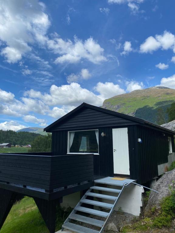 a black cabin with stairs leading up to it at Tiritoppen Cabin in Loen