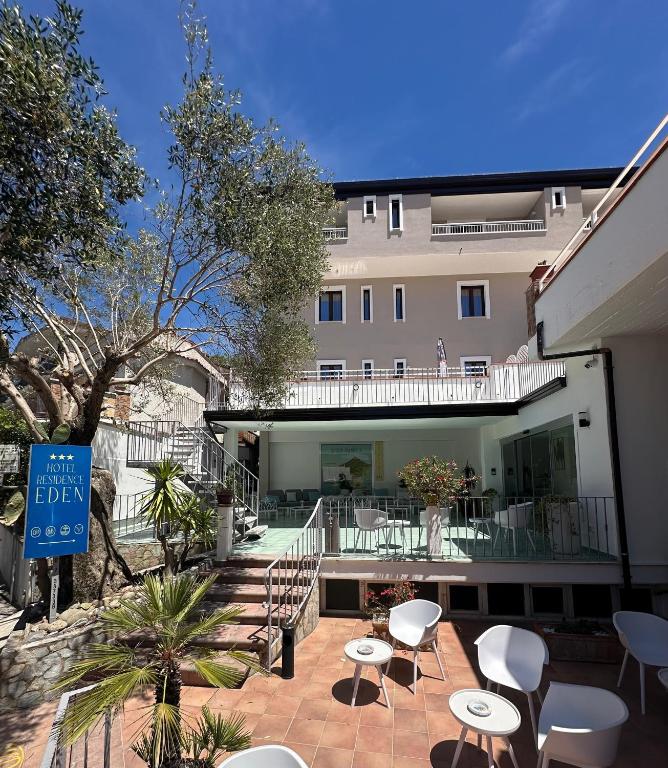 a hotel with chairs and tables in front of a building at Hotel Residence Eden in Palinuro