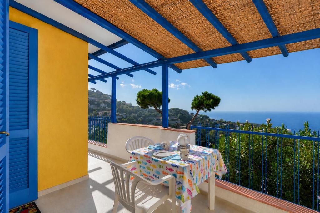 a table and chairs on a balcony with a view of the ocean at Bel Horizonte 7 in Capoliveri