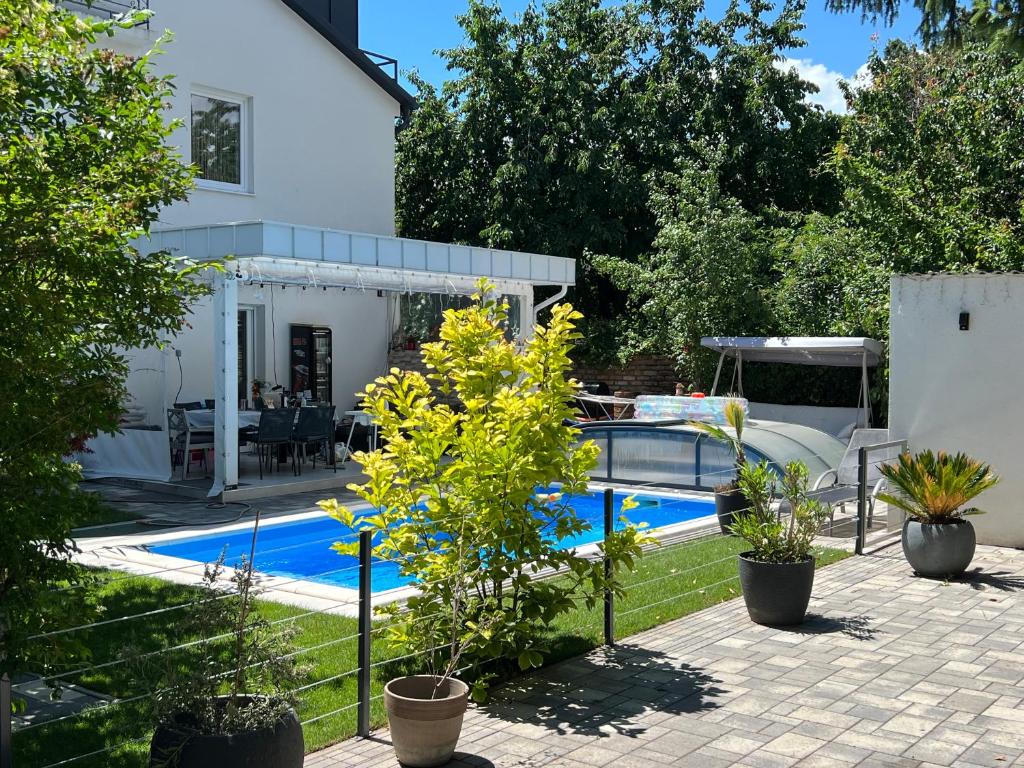 a swimming pool in front of a white house at Pool & Chill Balaton in Balatonvilágos