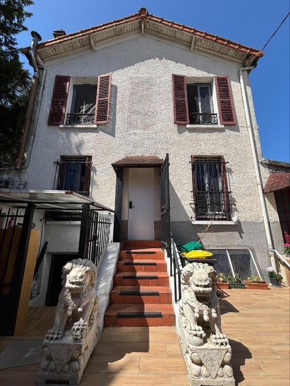 a house with a staircase leading to the front door at Soleil in Villejuif