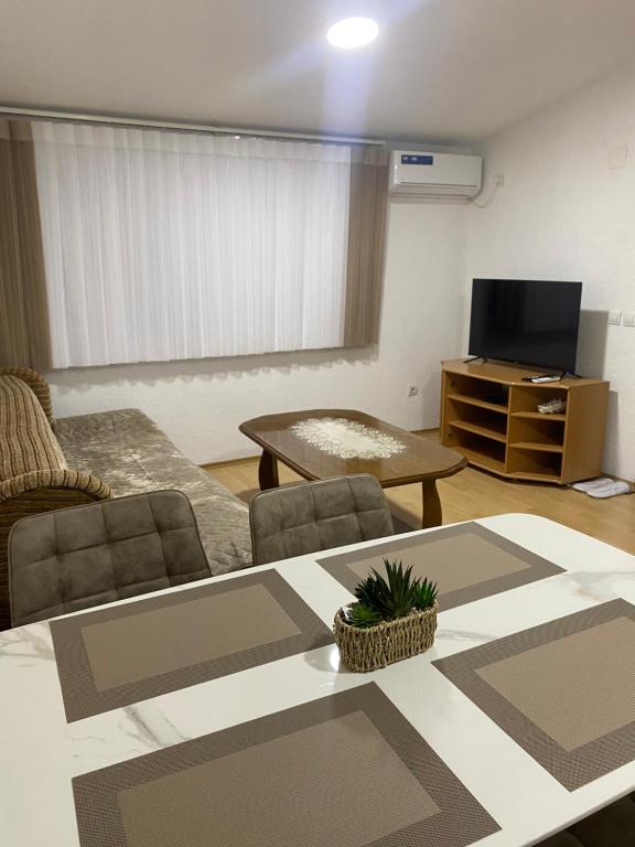 a living room with a table and a tv at Rena Comfort Apartment in Bar