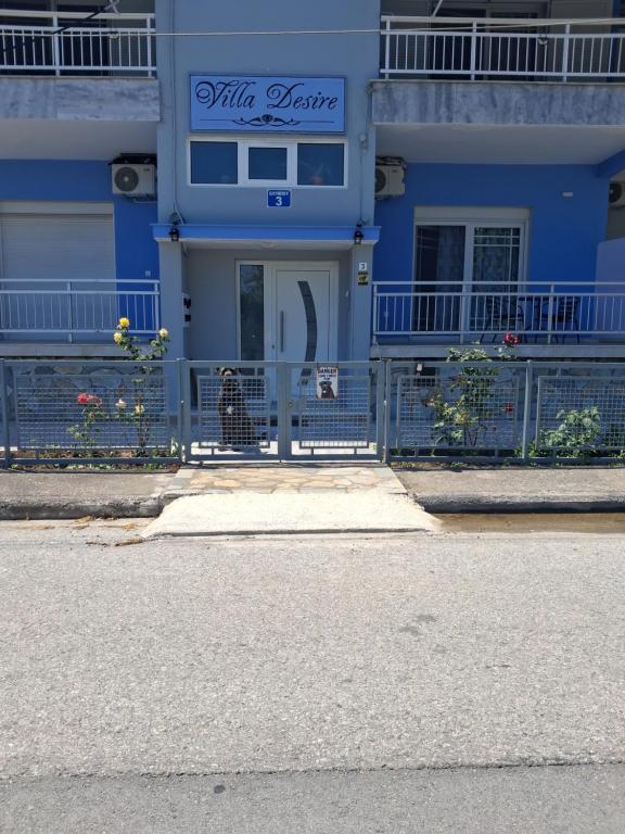 a blue building with a sign on the front of it at Villa Desire in Korinos