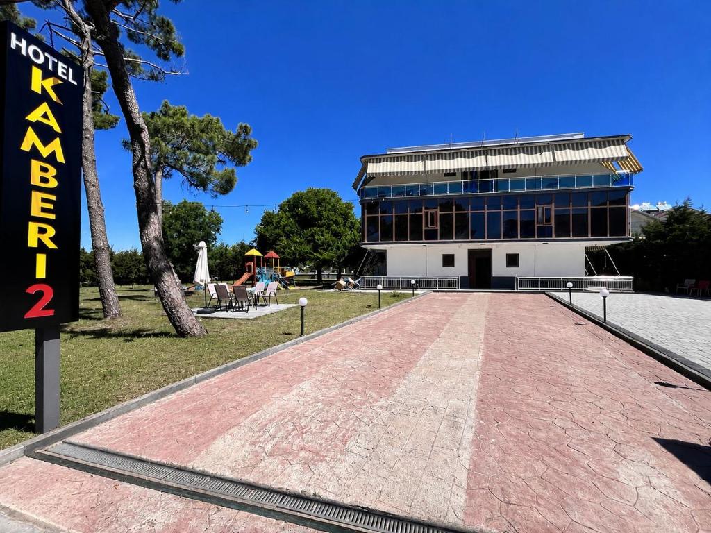 a building with a red brick road in front of it at Kamberi Hotel & Apartments 2 in Velipojë