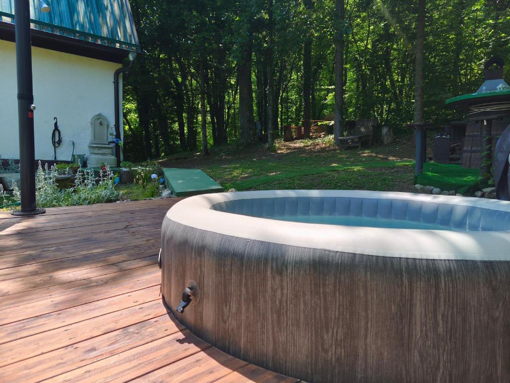 a hot tub sitting on a wooden deck at UNDER THE GREEN ROOF in Blaževića Dol