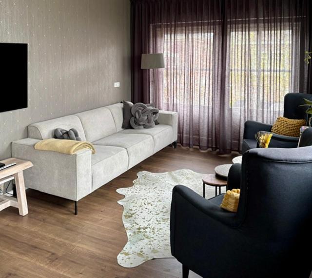 a living room with a couch and two chairs at B&B Tussen Vecht en Veer in Hardenberg
