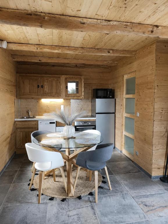 a dining room with a table and chairs in a kitchen at CHALET COSY A LA MONTAGNE AVEC SAUNA TONNEAU situé à St Laurent en Grandvaux - Proche lacs cascades et pistes de ski in Saint-Laurent-en-Grandvaux