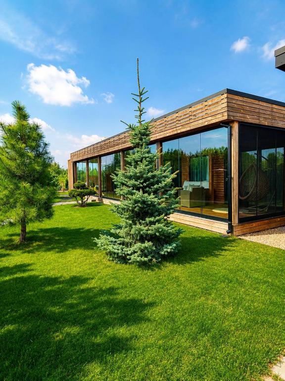 a glass house with a tree in the yard at Дивоніч guest house in Kyiv