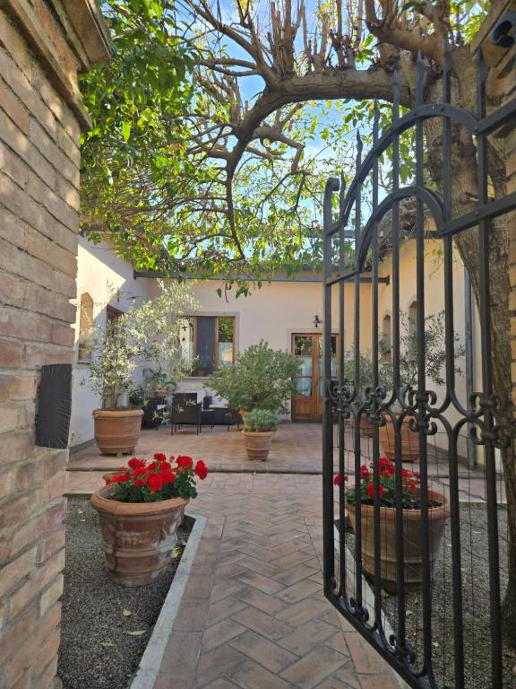an entry to a house with a gate with red flowers at La Primavera B&B in Volterra