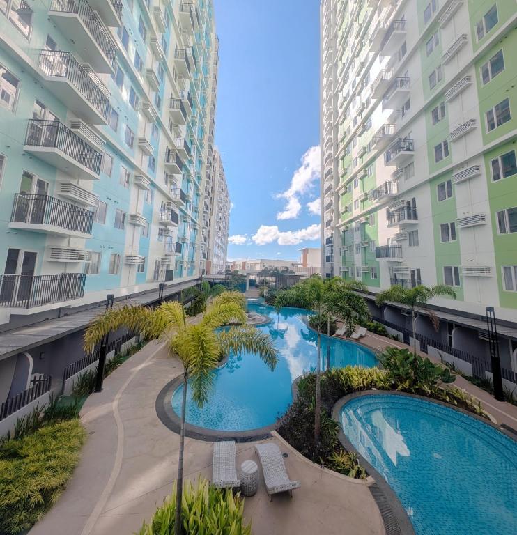 an aerial view of two swimming pools in the middle of two apartment buildings at Homey Studio Apartment in Mandaue in Mandaue City