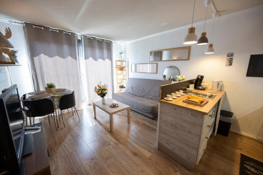a living room with a bed and a table in a room at Beau studio Pra loup 1500 in Pra-Loup