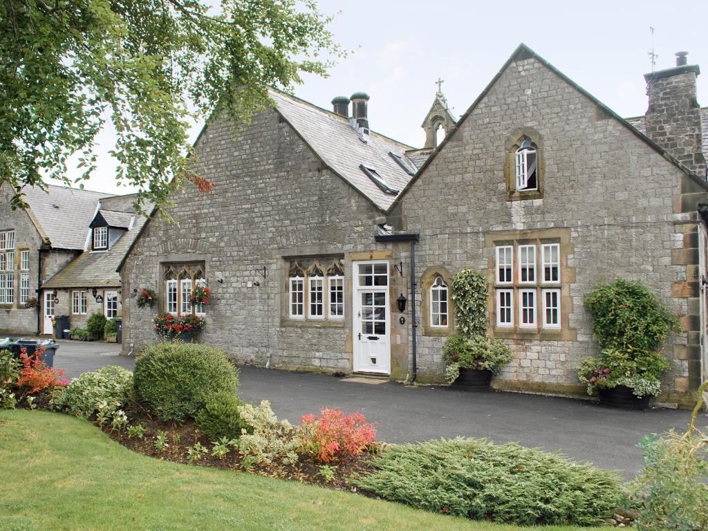an old brick house with a white door at The Old School House in Tideswell
