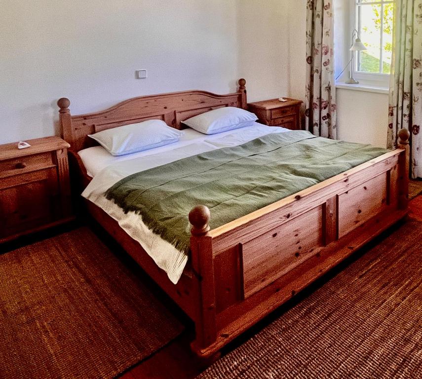 a bedroom with a large wooden bed with two pillows at Privatzimmer in Steinfeld