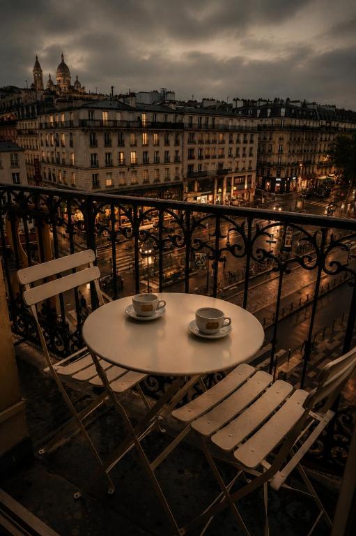 a table and two chairs on top of a balcony at La Villa Royale in Paris