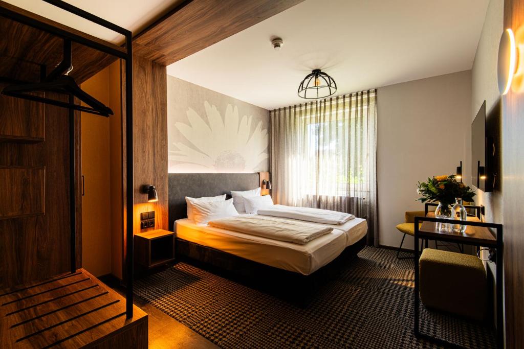 a hotel room with a bed and a window at Bundt's Hotel & Gartenrestaurant in Hamburg