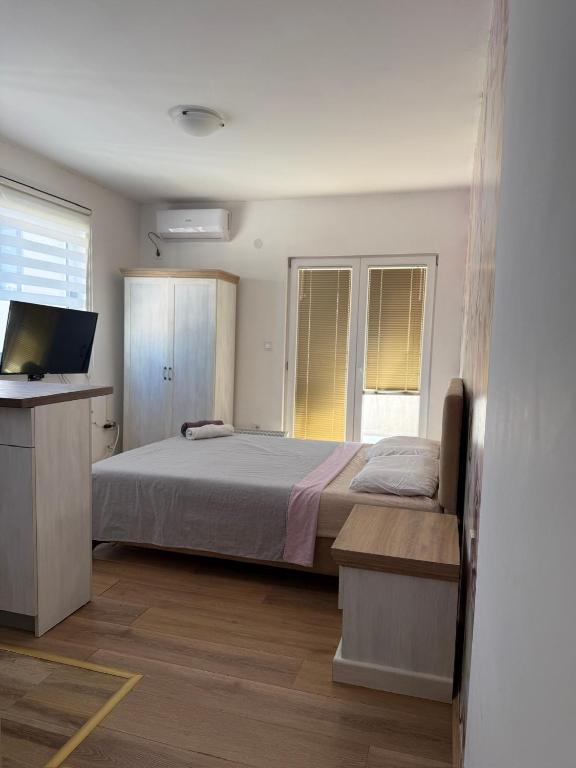 a bedroom with a bed and a flat screen tv at Jorgovan in Bečići