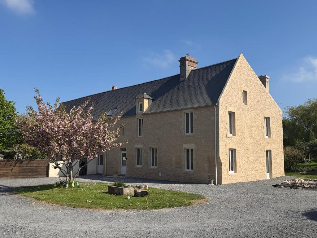 a large brick building with a black roof at Chambre à la campagne la ch tite bauquerie in Commes