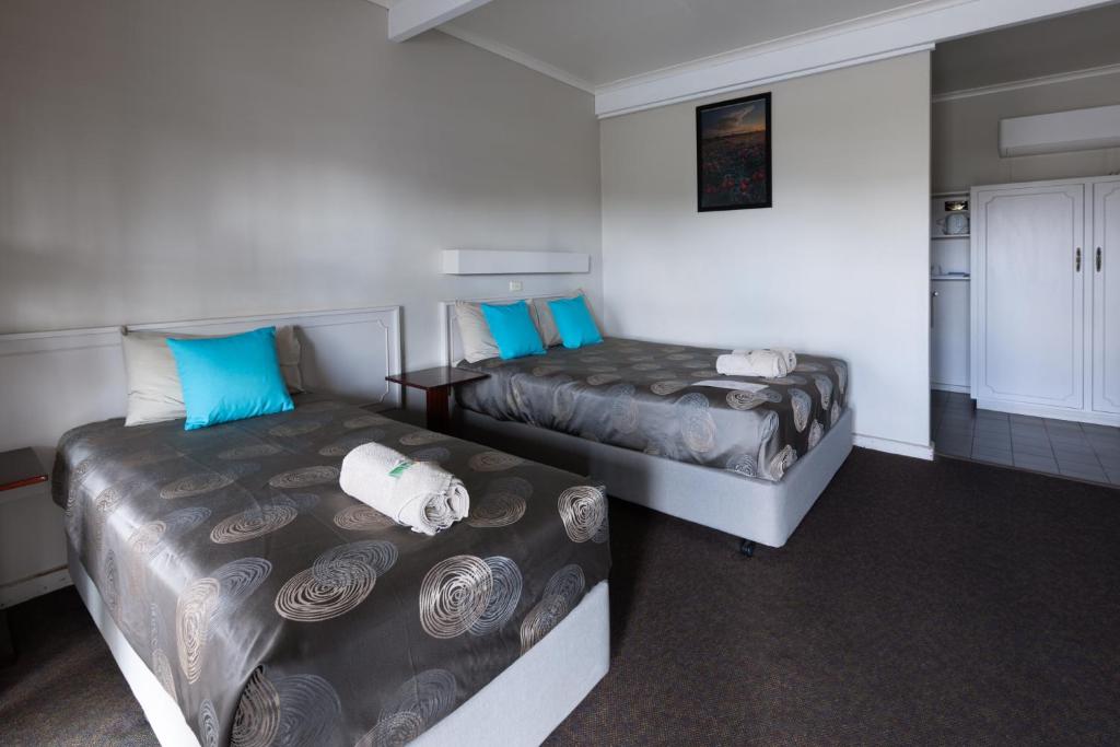 a small room with two beds and a kitchen at The Argent Motel in Broken Hill