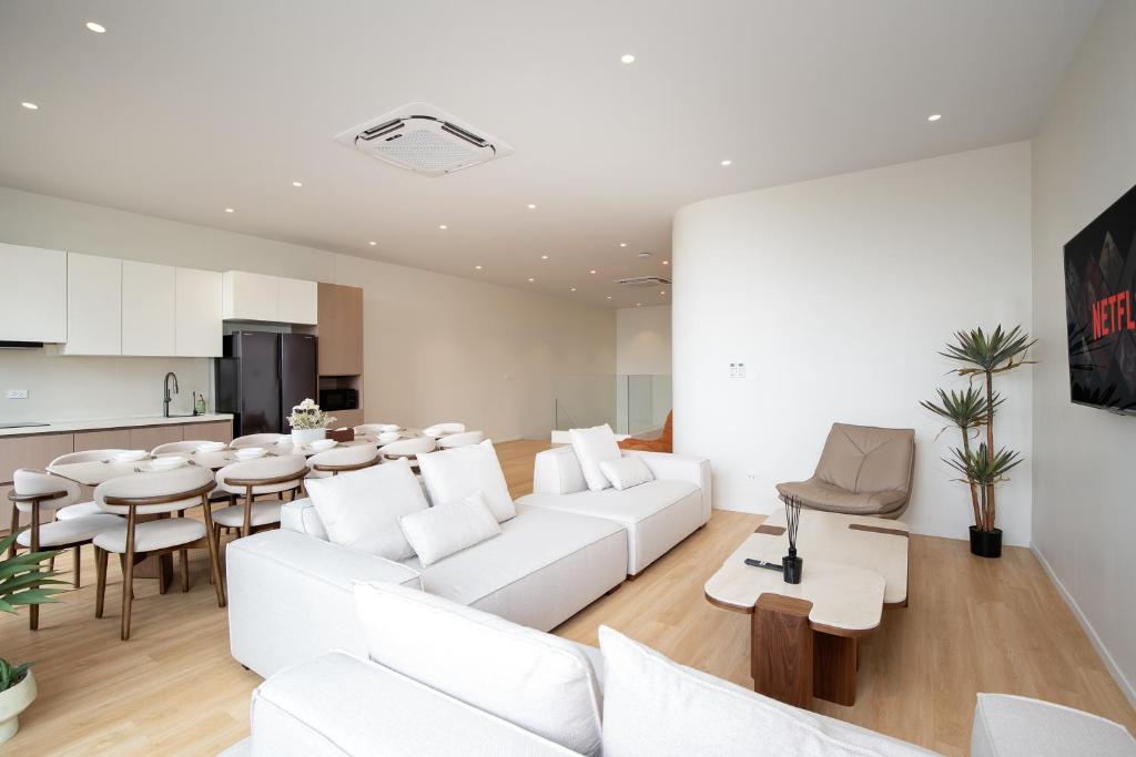 a living room with white furniture and a table at Haus 42 in Bangkok