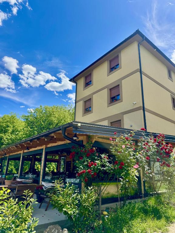 a large building with flowers in front of it at Zvjezdana dolina Garni hotel in Andrijevica