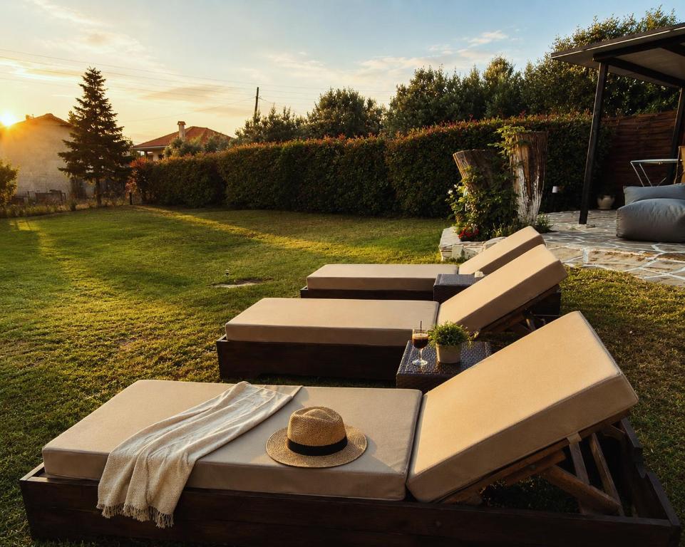 a group of lounge chairs with a hat on top at THAλEIA Holiday Home in Nea Kallikrateia