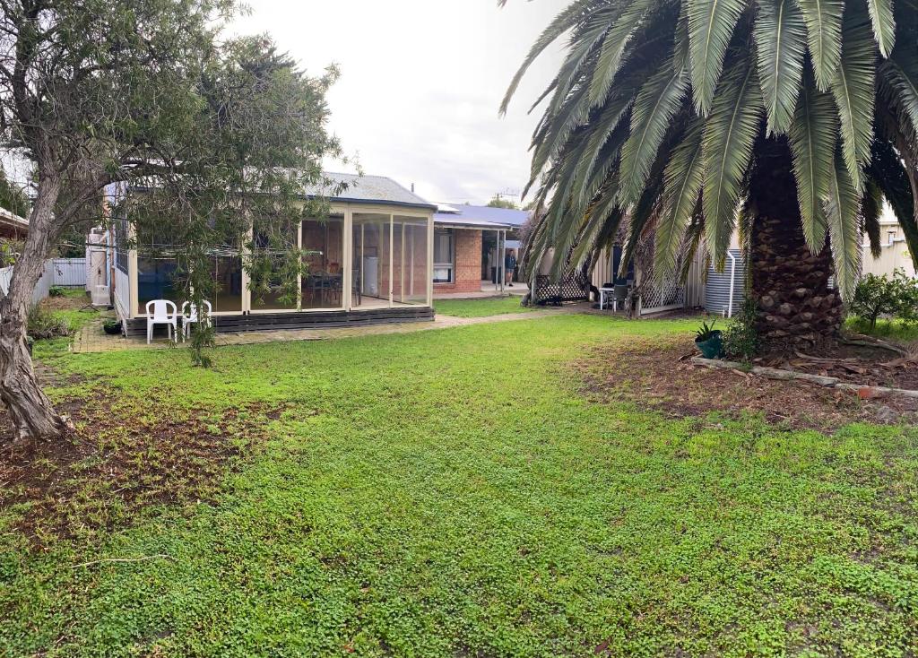 a yard with a house and a palm tree at Goolwa Retreat in Goolwa North