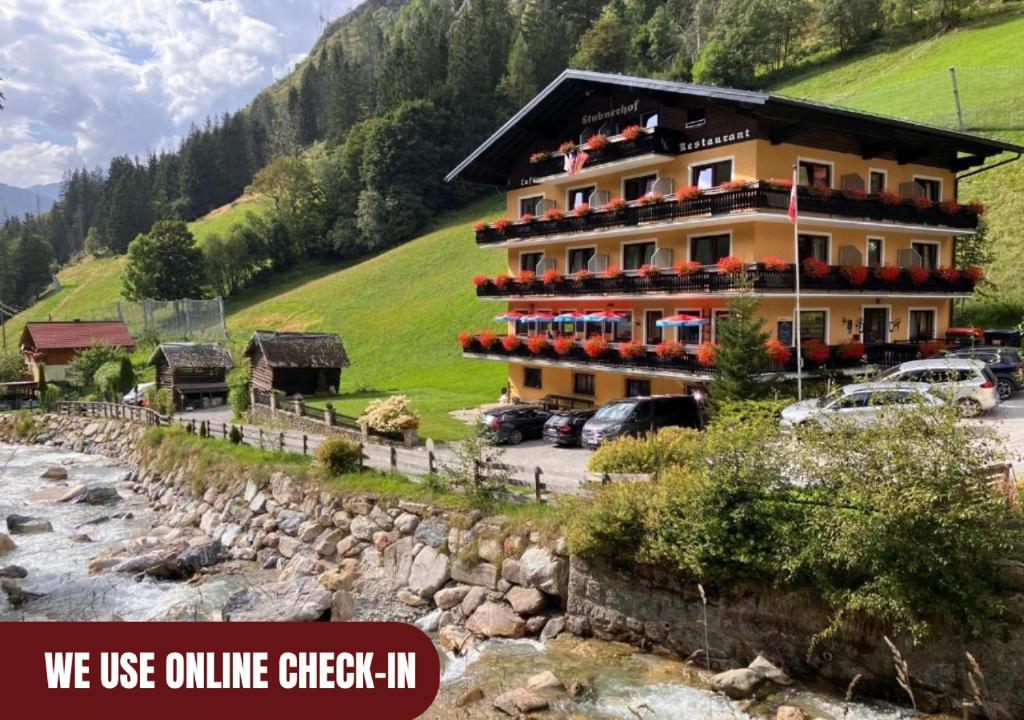 a building on a hill next to a river at Hotel Stubnerhof in Bad Gastein