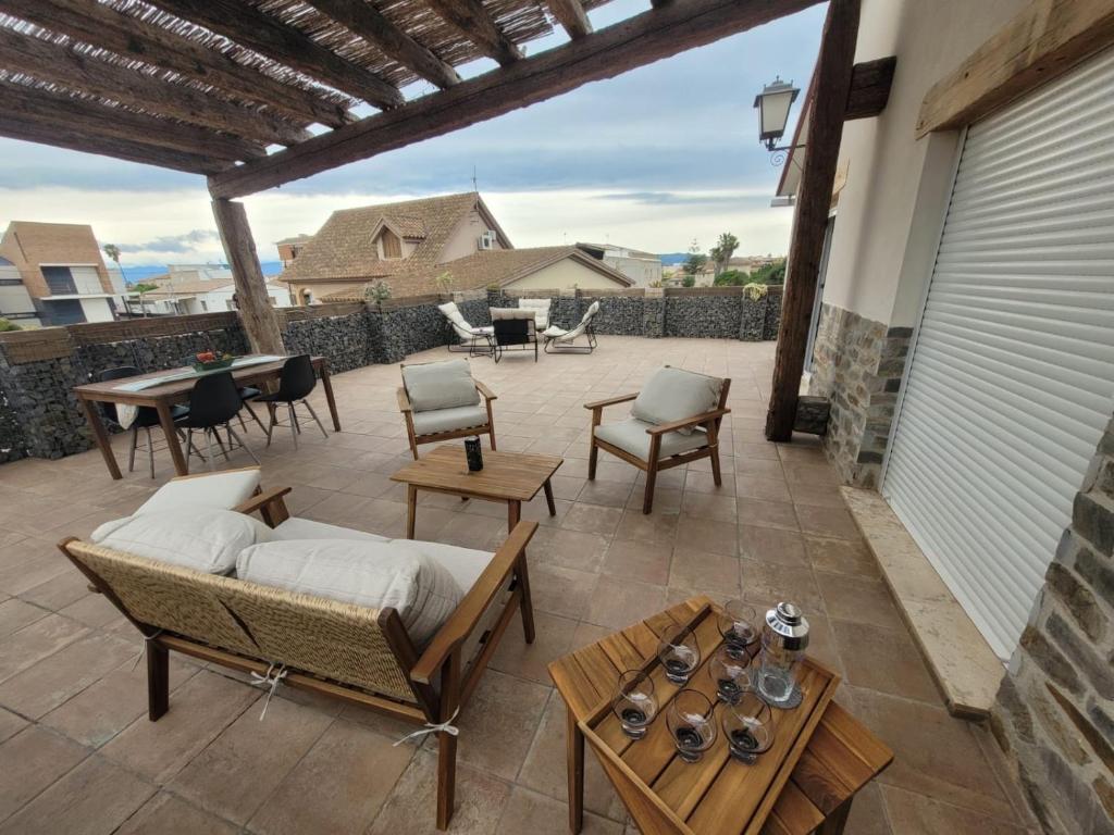 a patio with a couch and chairs and tables at Casa Rural Maño in Deltebre
