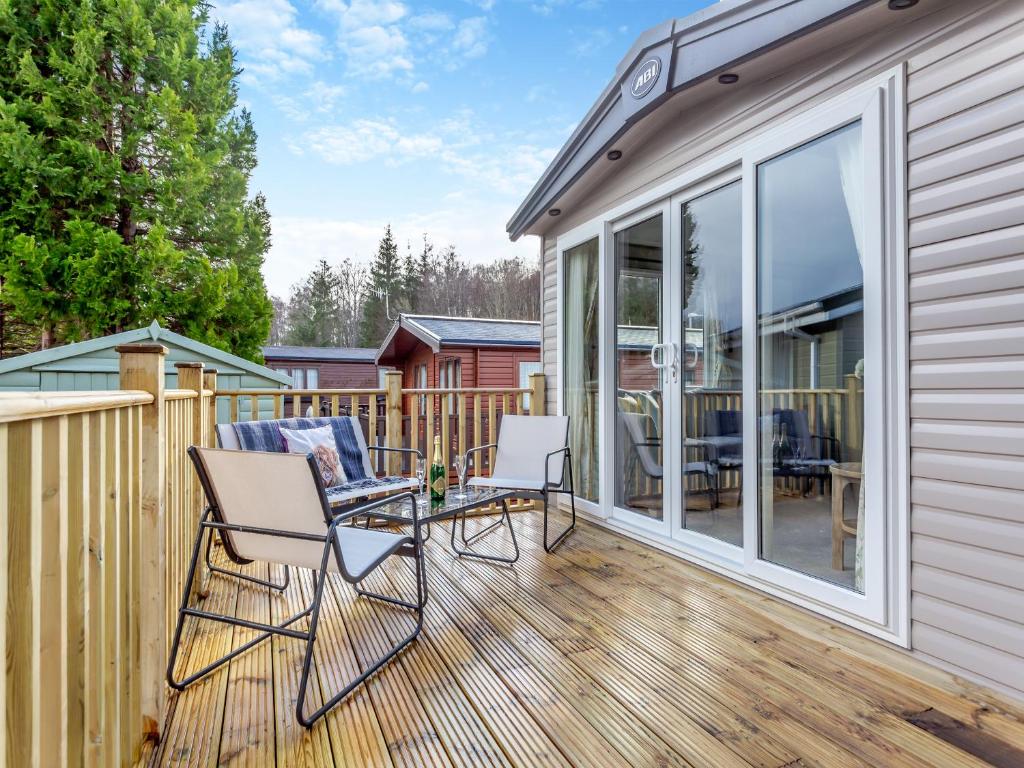 a patio with chairs and a table on a deck at The Pines in Aviemore