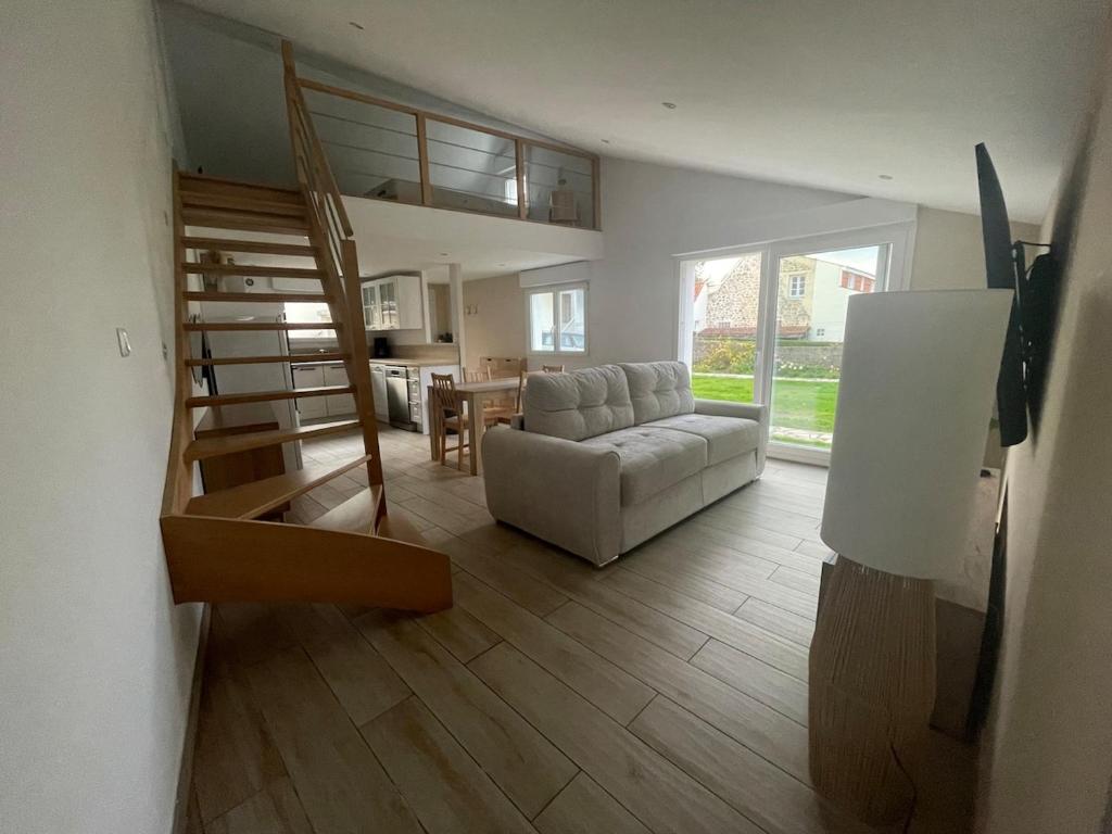 a living room with a couch and a staircase at Sable d or wissant in Wissant