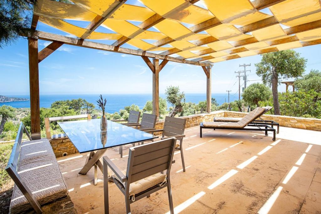 a patio with a table and chairs and the ocean at Nous Village 2 in Alyki