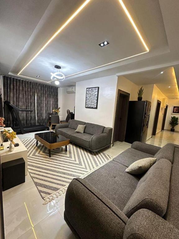 a large living room with a couch and a table at SKYBUILT APARTMENTs in Abuja