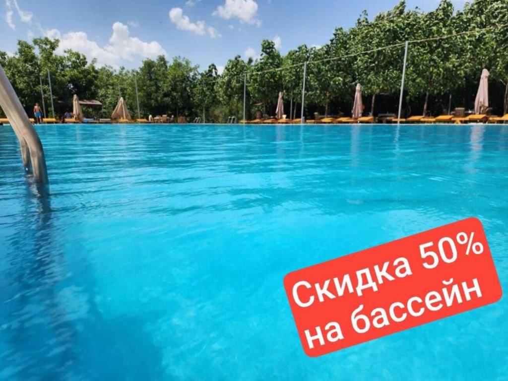 a swimming pool with a sign in the water at Room4you in Tashkent