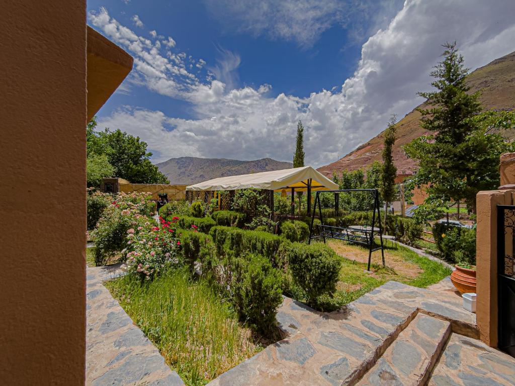 a garden with a gazebo and some bushes at Tonaroz House in Imlil