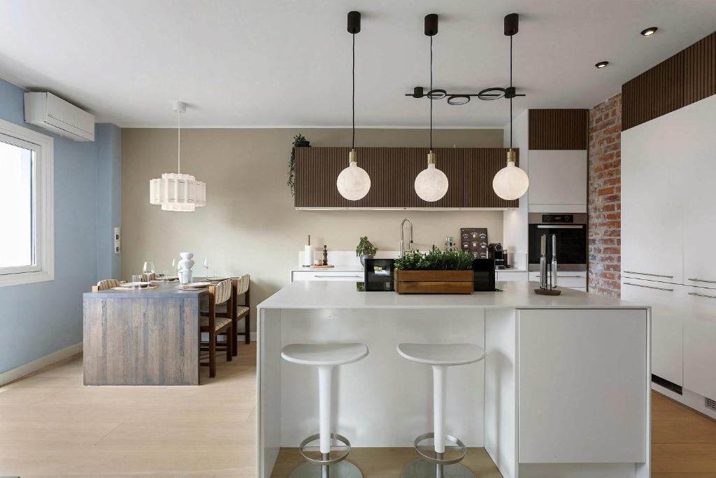 a kitchen with a white island with bar stools at 5BR 2Bath Frogner - Parking - Vigelandsparken in Oslo