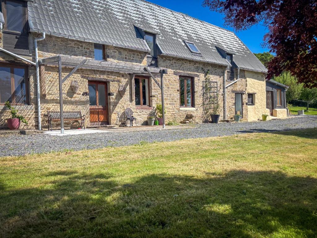 a stone house with a bench in front of it at Le Marronnier in Montchauvet