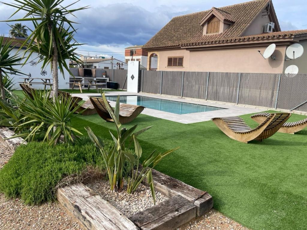 a yard with chairs and a swimming pool at Casa rural Mestre in Deltebre