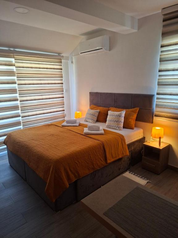 a bedroom with a large bed with orange sheets and pillows at Zara spa free in Veliko Gradište