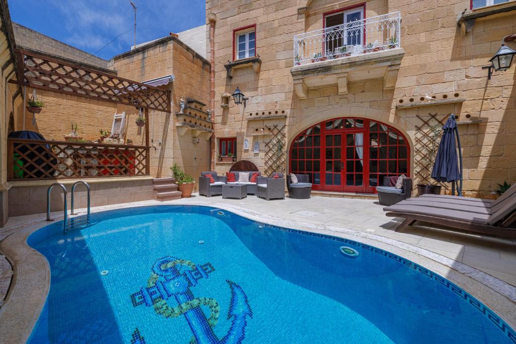 a swimming pool in front of a building at Ta' Kullarina Farmhouse in Żebbuġ