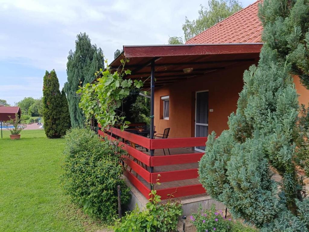 a house with a red roof and some bushes at Mia Cottage in Ordacsehi