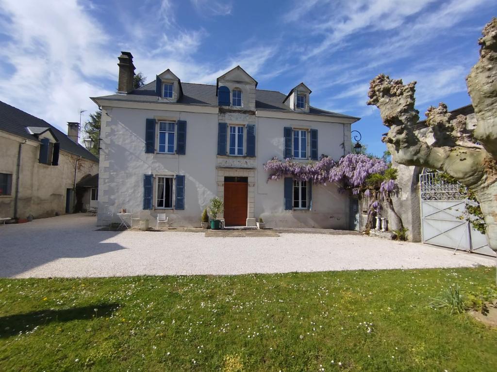 a large white house with purple wreaths at B&B chez Nicole in Montaut