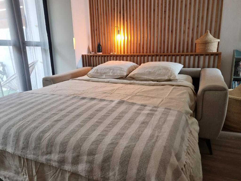 a bedroom with a large bed with a striped comforter at Studio Maison à Saint-Denis in Saint-Denis