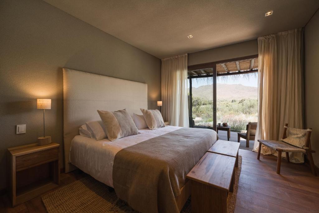 sypialnia z dużym łóżkiem i dużym oknem w obiekcie Macal Cachi Luxury Lodge w mieście Cachí