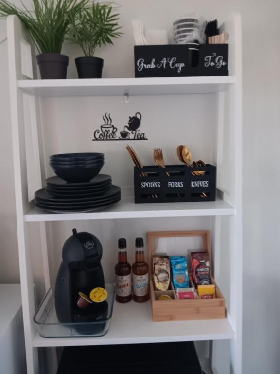 a white pantry with dishes and utensils at Studio Leilighet in Moss