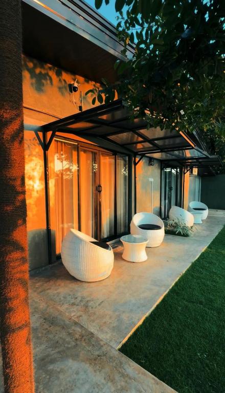 a row of white benches sitting next to a building at Trump House in Anuradhapura
