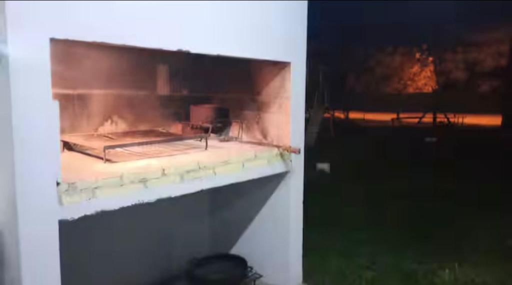 a fire inside of a building with a fire place at Quincho Paysandu in Arroyo Seco