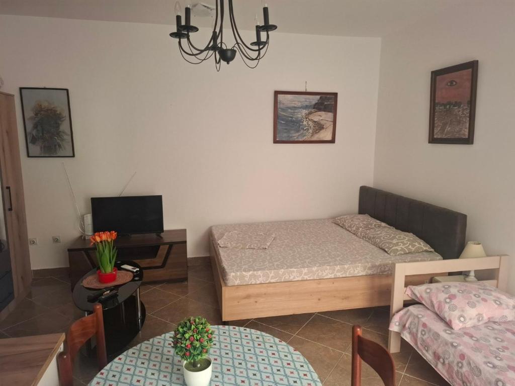 a small room with a bed and a table and a dining room at Harmony in Budva