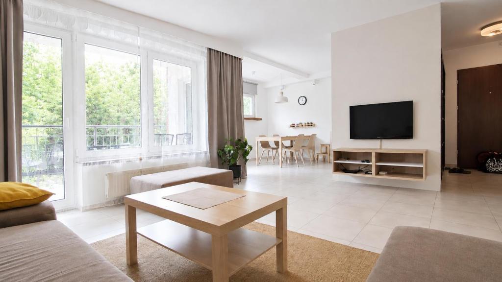 a living room with a couch and a tv at Apartament Bukovy Wisła in Wisła